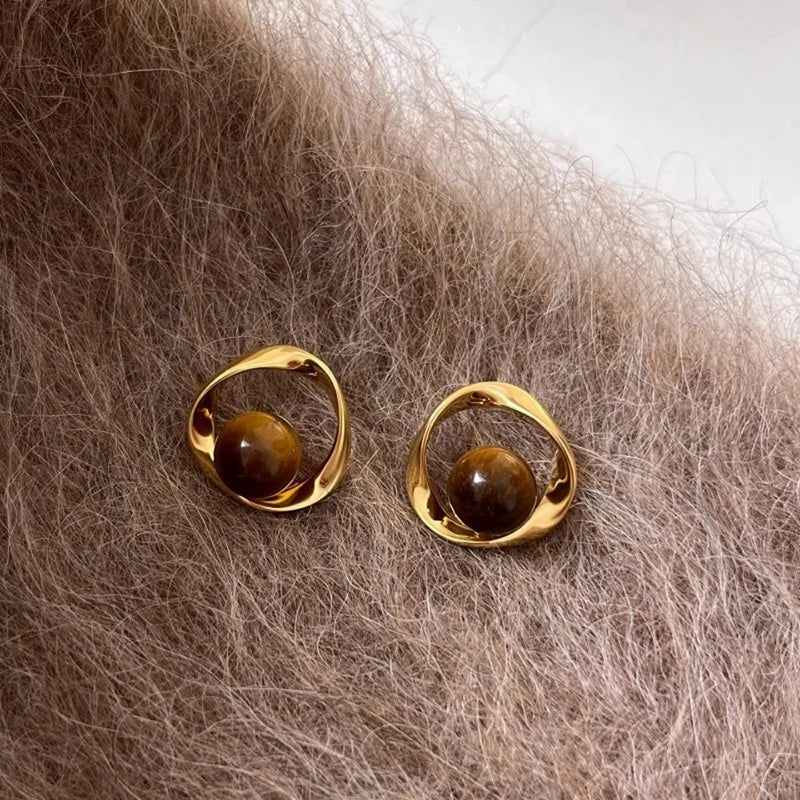 Goldene gewellte Ohrringe und Perlen in Tigeraugen-Optik