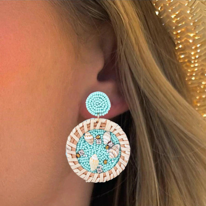 Hängende Ohrringe mit Kaurimuschel