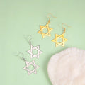 Sechseckige hängende Ohrringe mit dem jüdischen Symbol des <span data-glossary-id="star_of_david">Davidsterns</span> in Gold