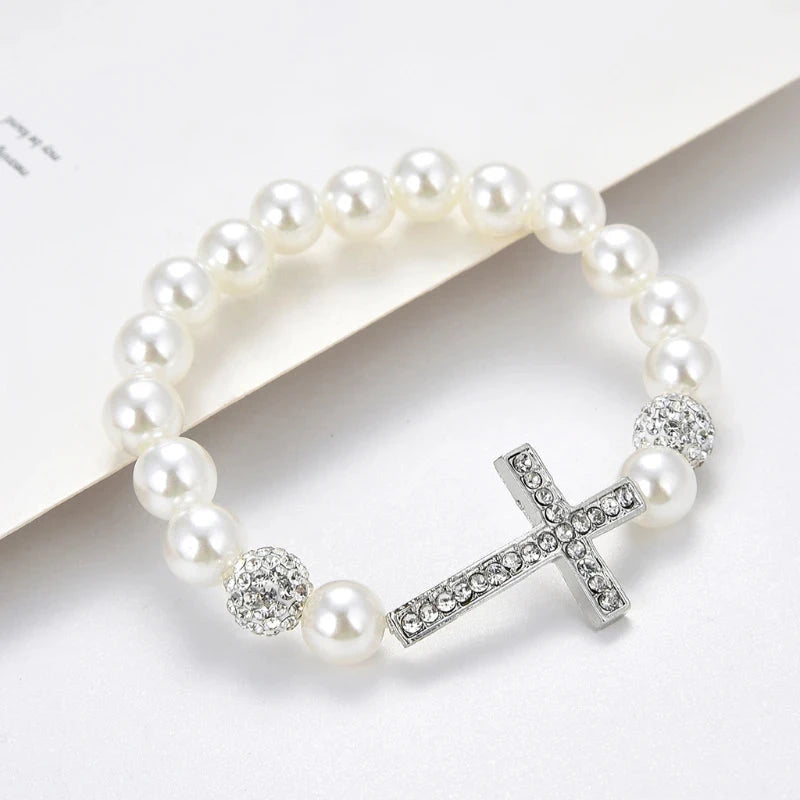 Armband mit weißen Perlen und Kreuz