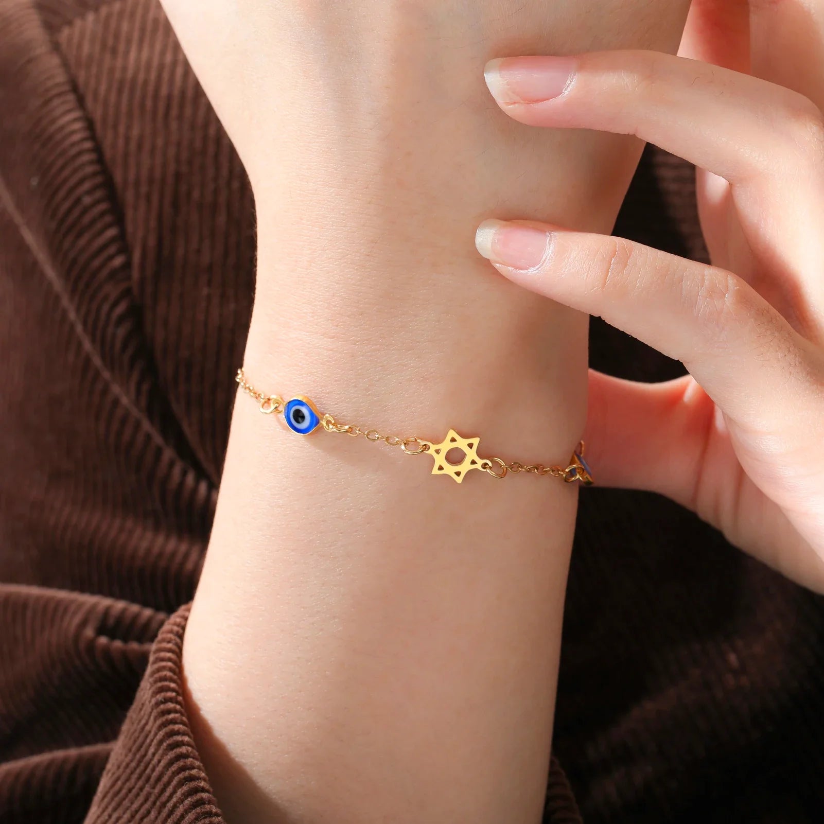 Armband mit Schutzsymbolen blaues Auge, Chai und dem <span data-glossary-id="davidstern">Davidstern</span> Gold