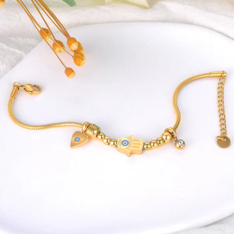Schutzarmband mit Fatimas Hand und blauem Auge in Gold