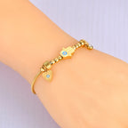 Schutzarmband mit Fatimas Hand und blauem Auge in Gold