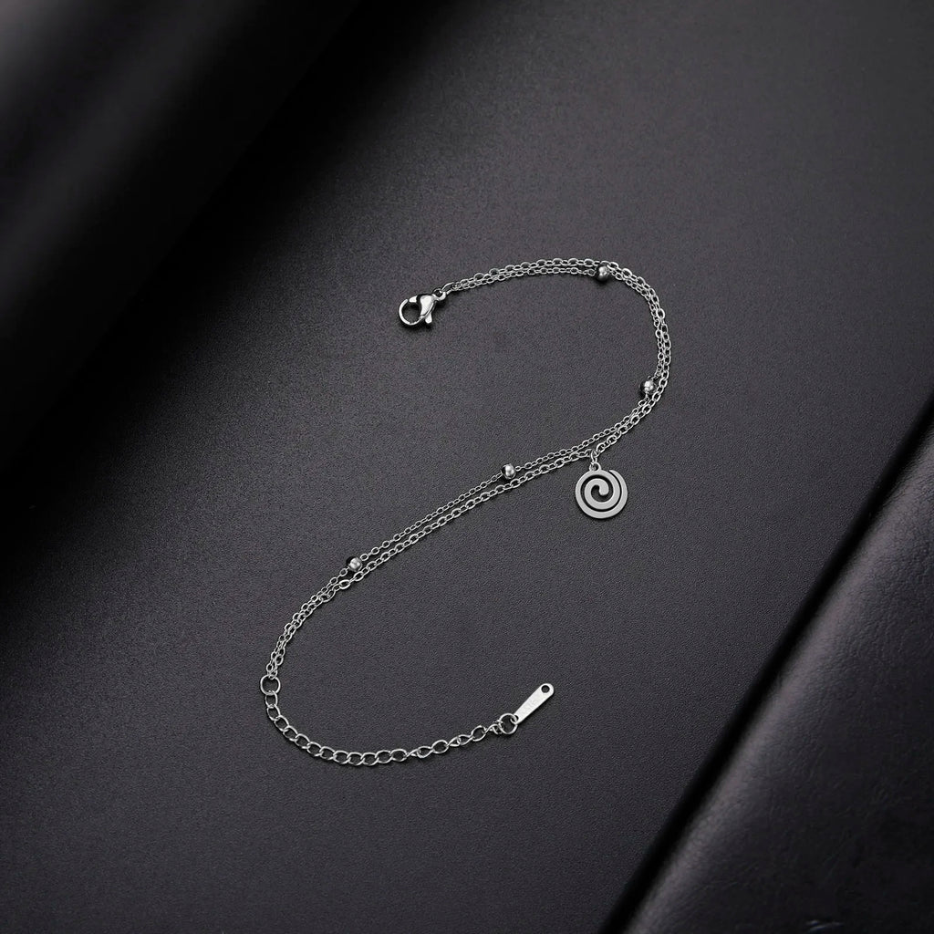 Vergoldetes Armband mit kleinem spiralförmigen silbernen Anhänger