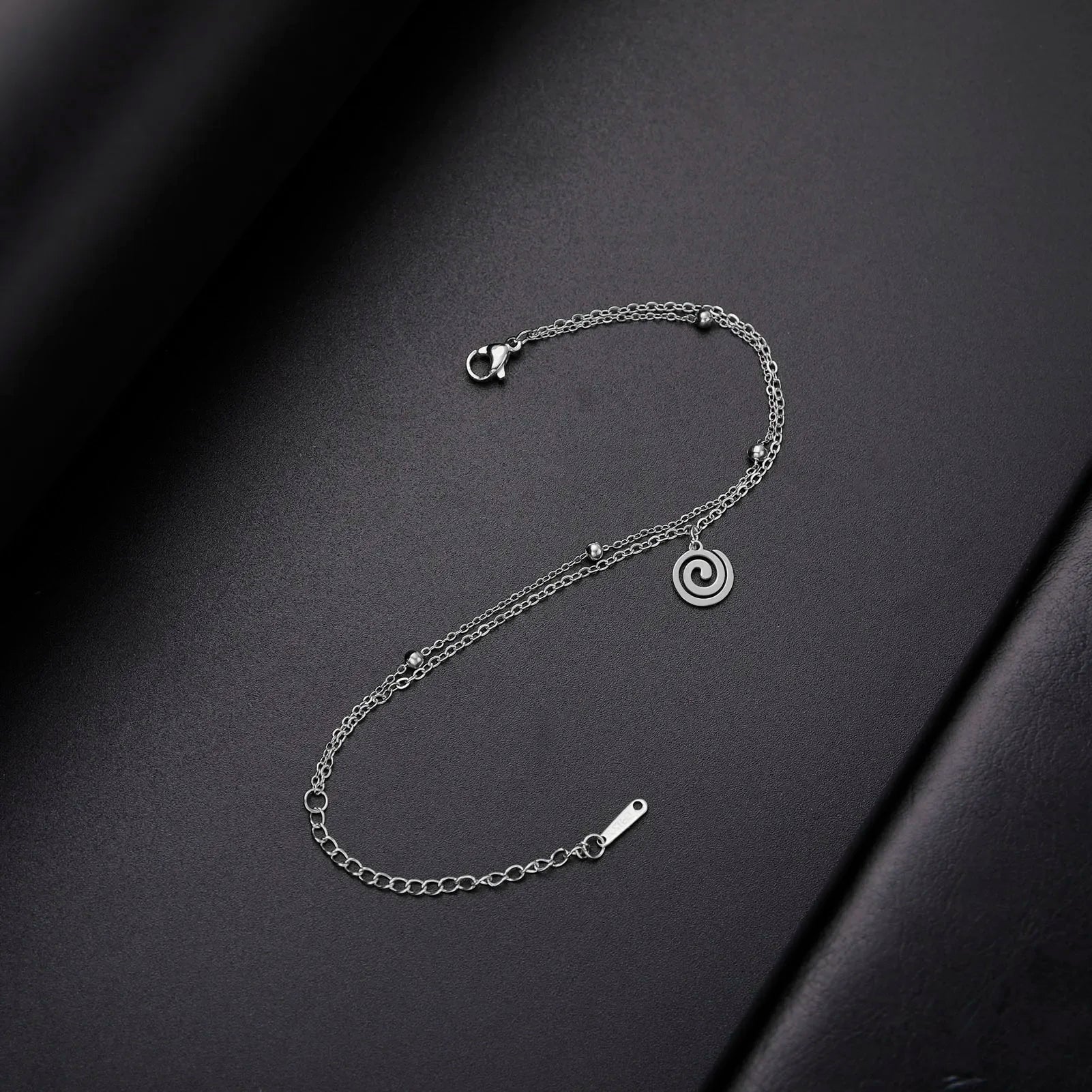 Vergoldetes Armband mit kleinem spiralförmigen silbernen Anhänger