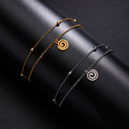Vergoldetes Armband mit kleinem spiralförmigen silbernen Anhänger
