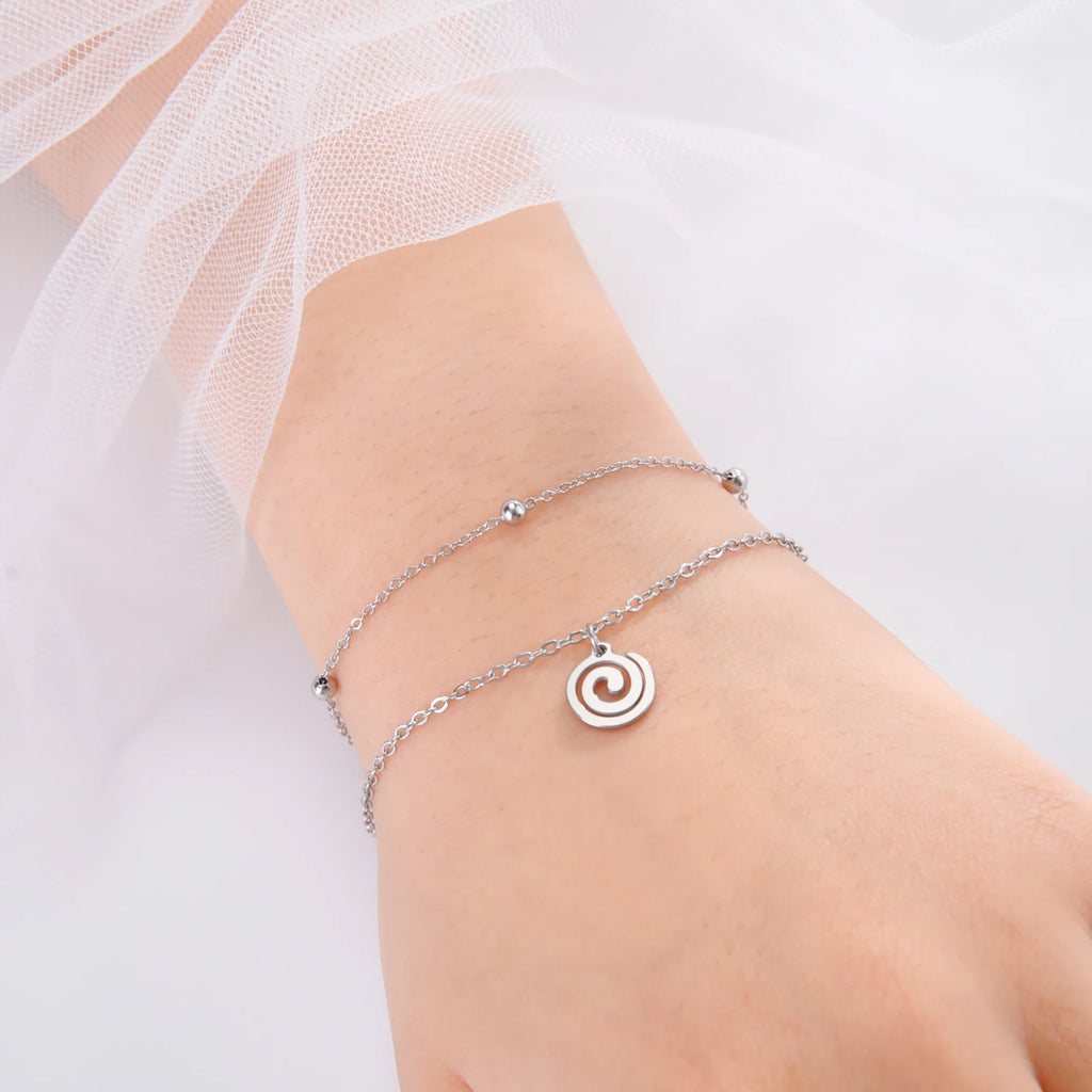 Vergoldetes Armband mit kleinem spiralförmigen silbernen Anhänger