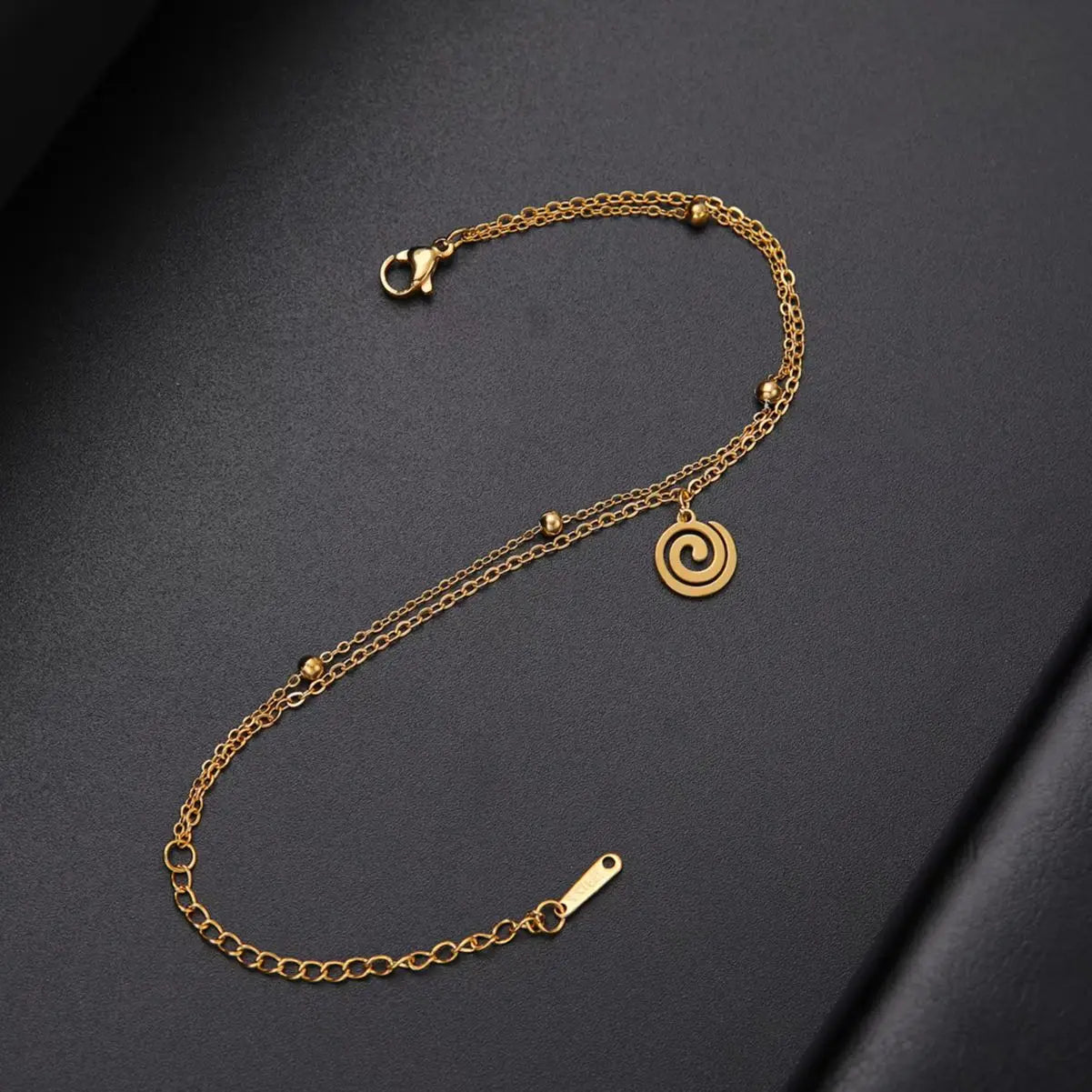 Vergoldetes Armband mit kleinem spiralförmigen goldenen Anhänger