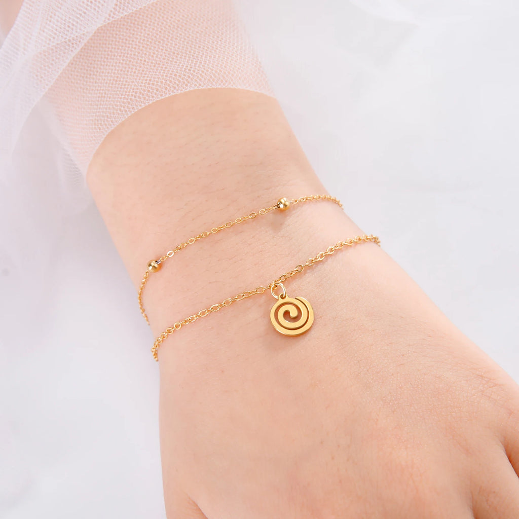 Vergoldetes Armband mit kleinem spiralförmigen goldenen Anhänger