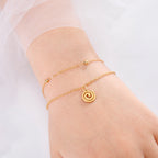 Vergoldetes Armband mit kleinem spiralförmigen goldenen Anhänger