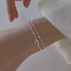 Armband mit doppeltem Herz und Perlen
