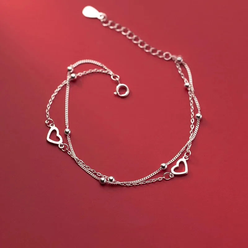 Armband mit doppeltem Herz und Perlen