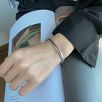 Offenes Armreif-Armband mit silberner Feder