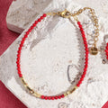 Korallenrotes und goldenes Armband