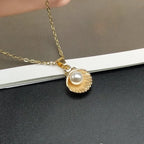 Halskette mit Anhänger Jakobsmuschel und goldene Perle