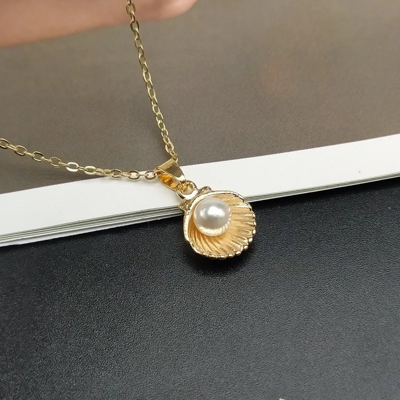 Halskette mit Anhänger Jakobsmuschel und goldene Perle