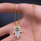 Lange Halskette mit Anhänger zum Schutz vor dem bösen <span data-glossary-id="œil">Auge</span> und arabischer Fatma-Hand in Gold