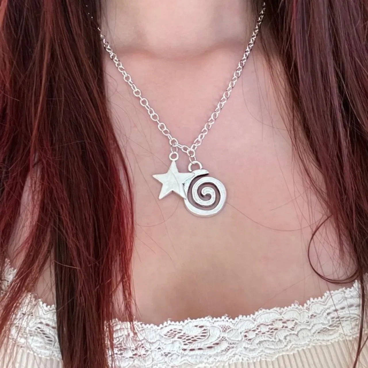 Halskette mit spiralförmigem Anhänger und kleinem Stern