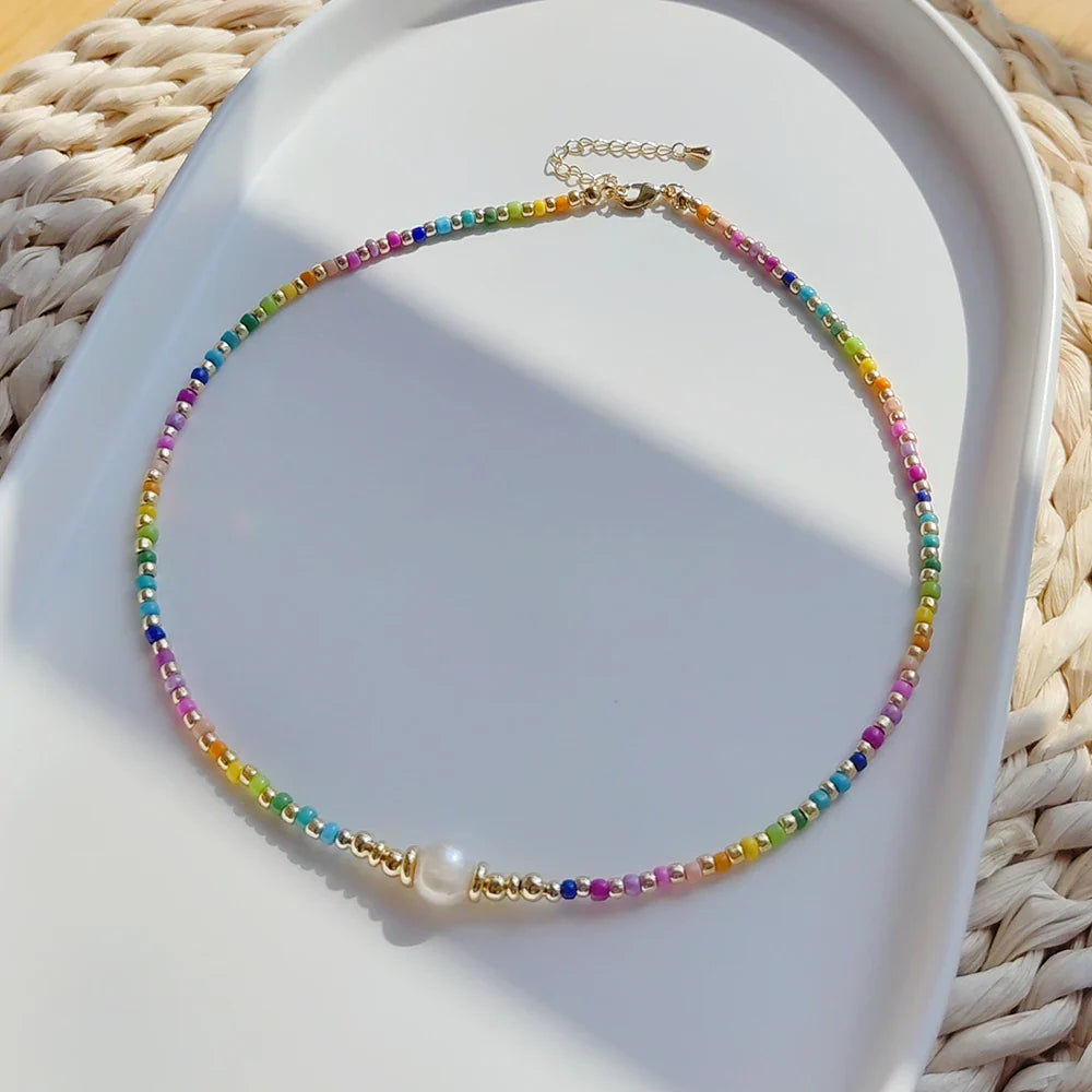 Halskette mit eng anliegendem Halsband und Regenbogenanhänger und Perlen