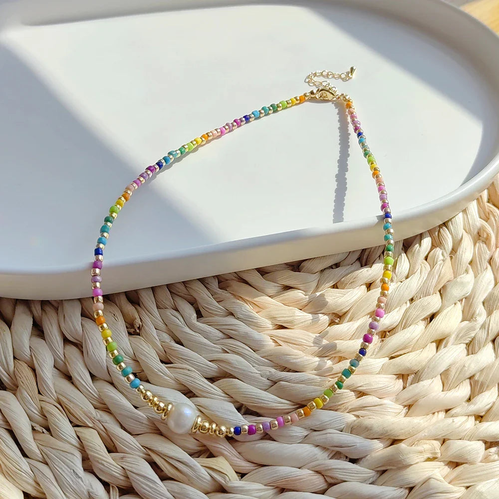 Halskette mit eng anliegendem Halsband und Regenbogenanhänger und Perlen