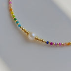 Halskette mit eng anliegendem Halsband und Regenbogenanhänger und Perlen