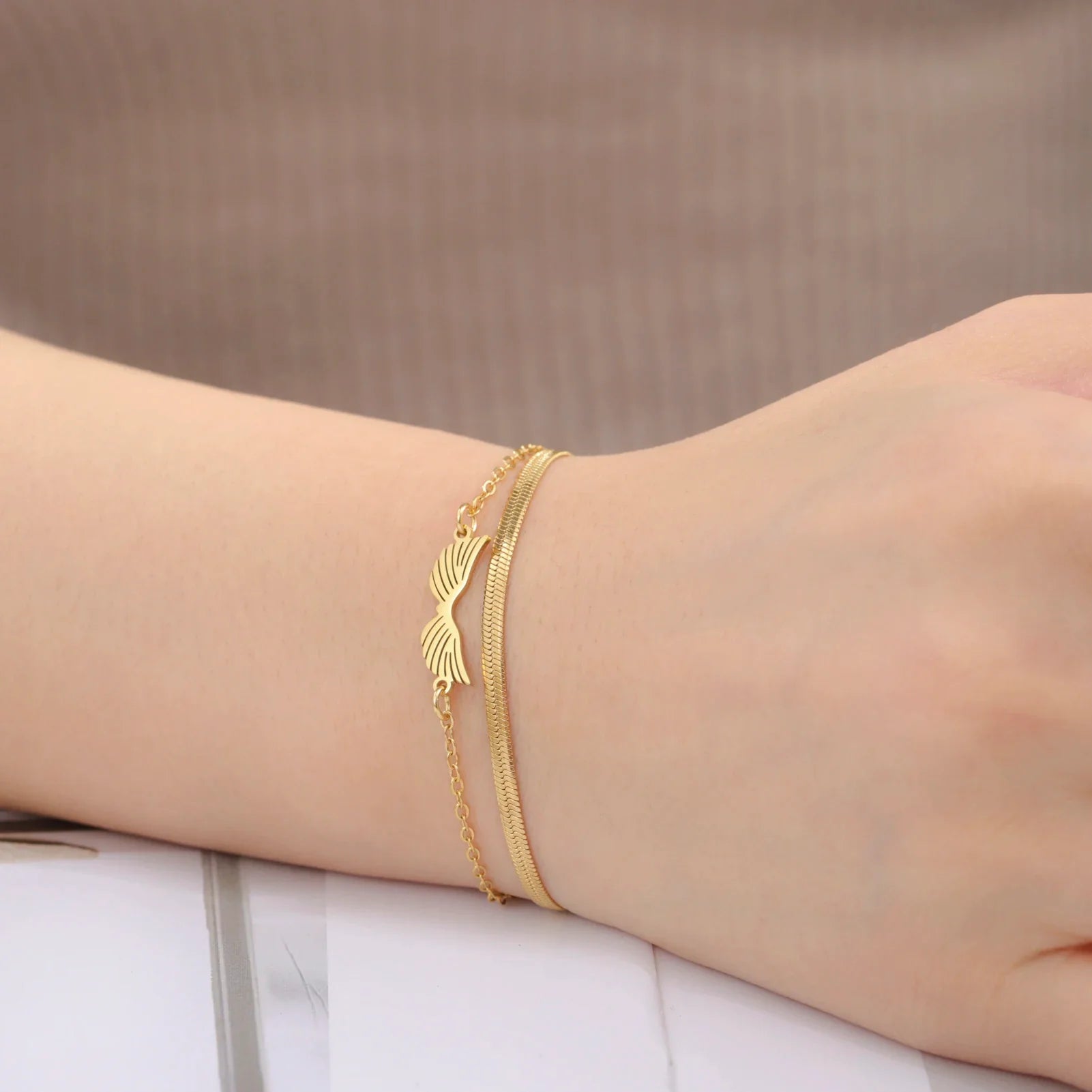 Doppelarmband mit goldenen Engelsflügeln