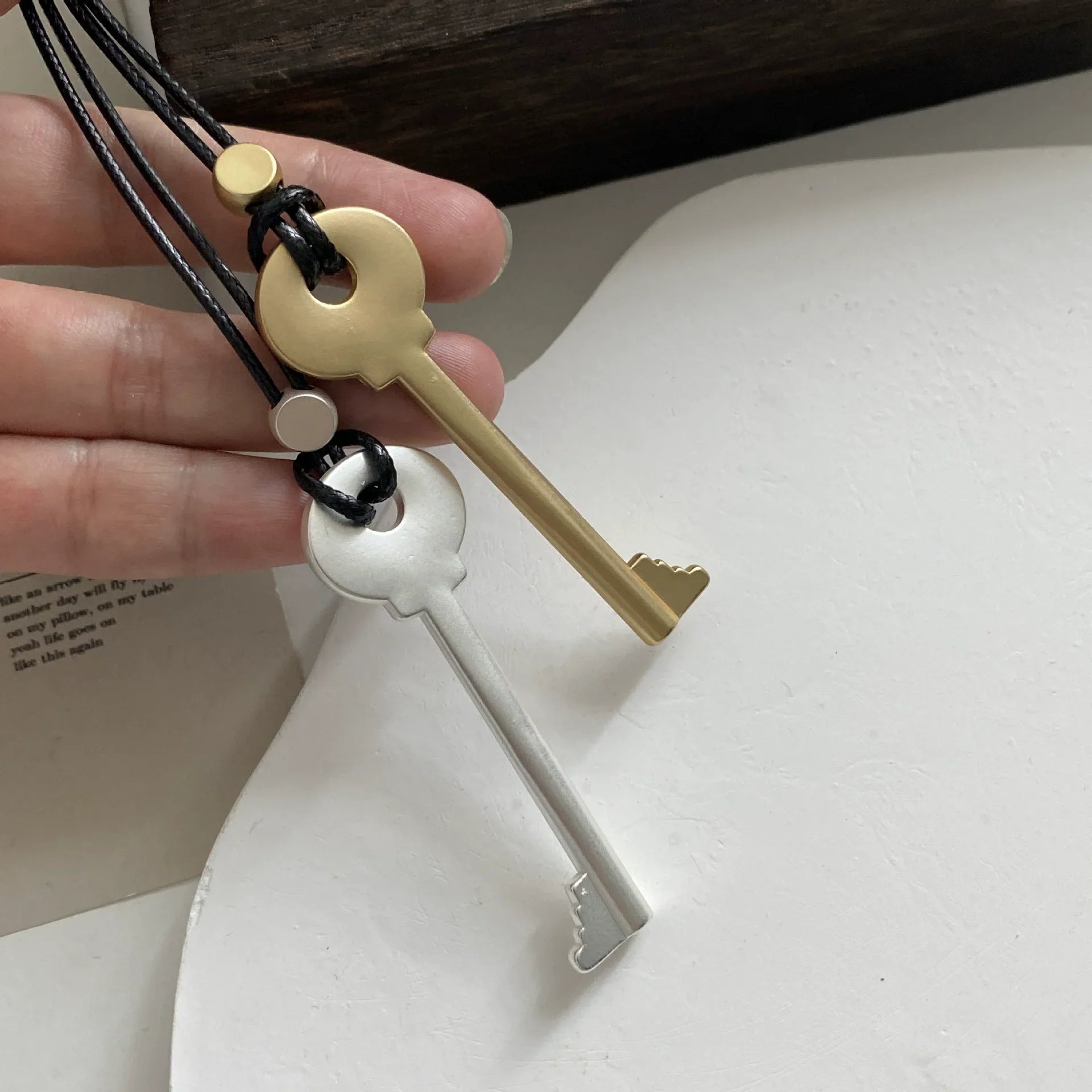 Lange Kette aus Kordel mit matt silbernem Schlüsselanhänger