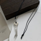 Lange Kette aus Kordel mit glänzend silbernem Schlüsselanhänger